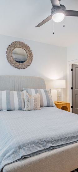 Botanic Luxury Apartments Bright bedroom with a bed, pillows, and matching nightstands, featuring modern decor and natural light from a large window.